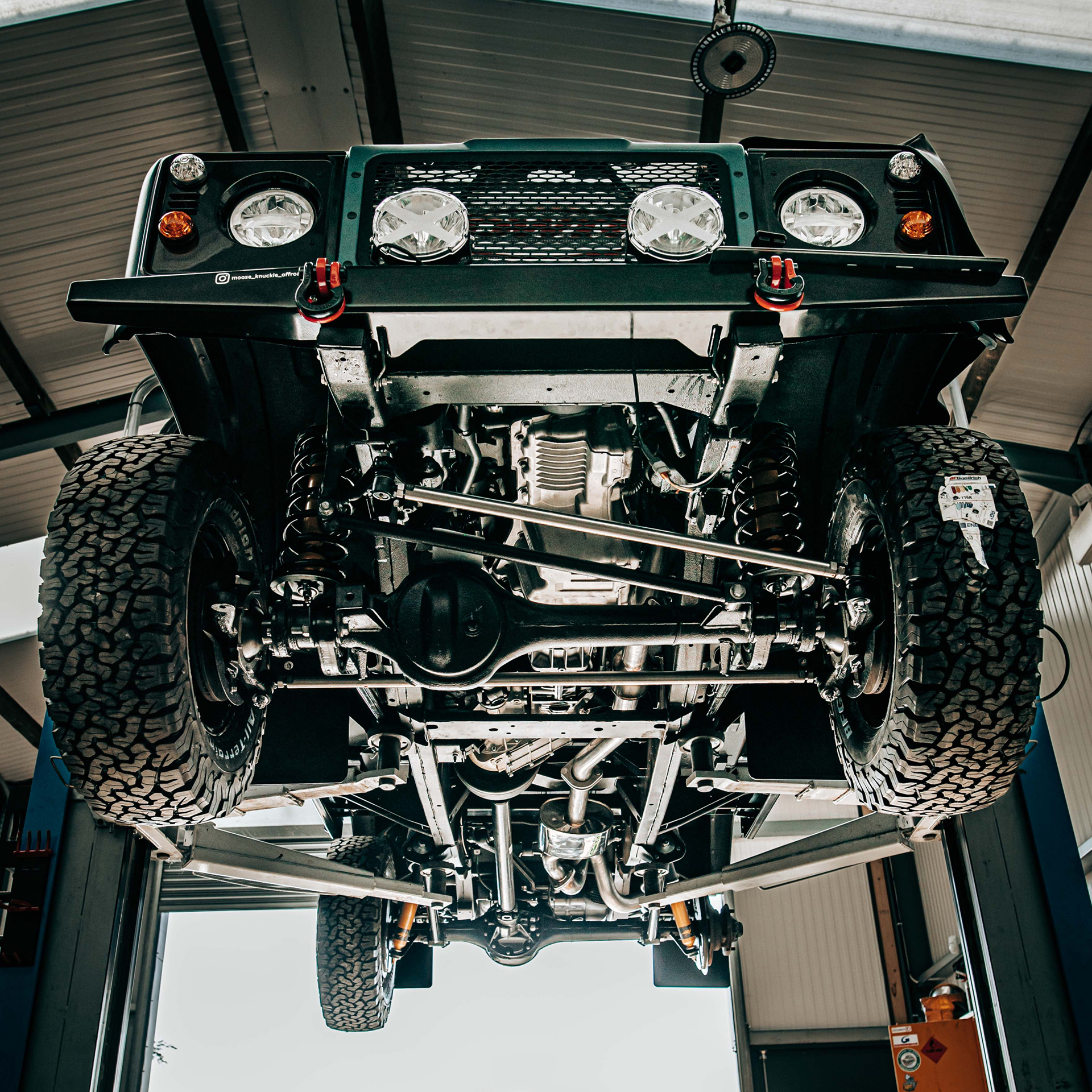 Underside of a Land Rover Defender on a vehicle lift